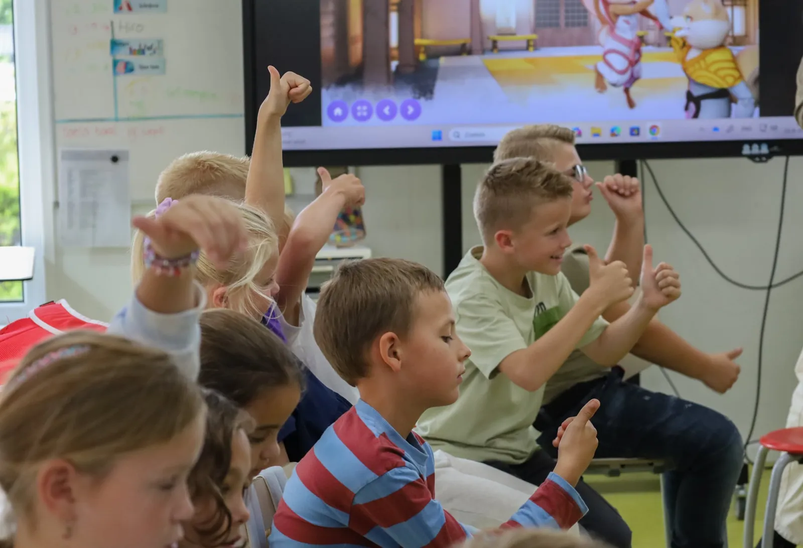 Klas steekt enthousiast de duimen omhoog tijdens een HiRO les op het digibord